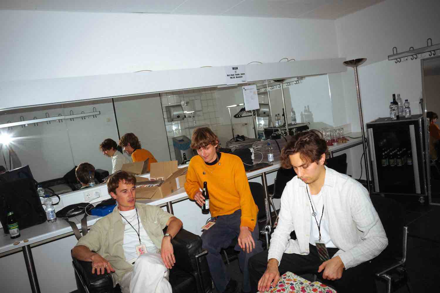 The band gathered around desks in a bright studio control room