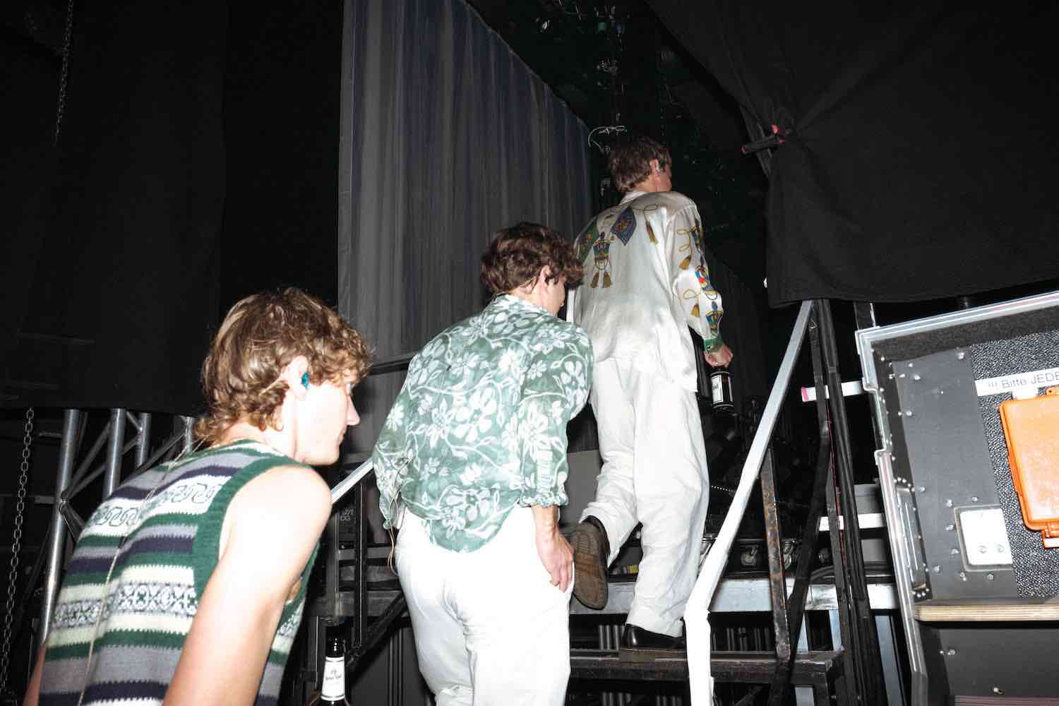 The band backstage among flight cases and monitors