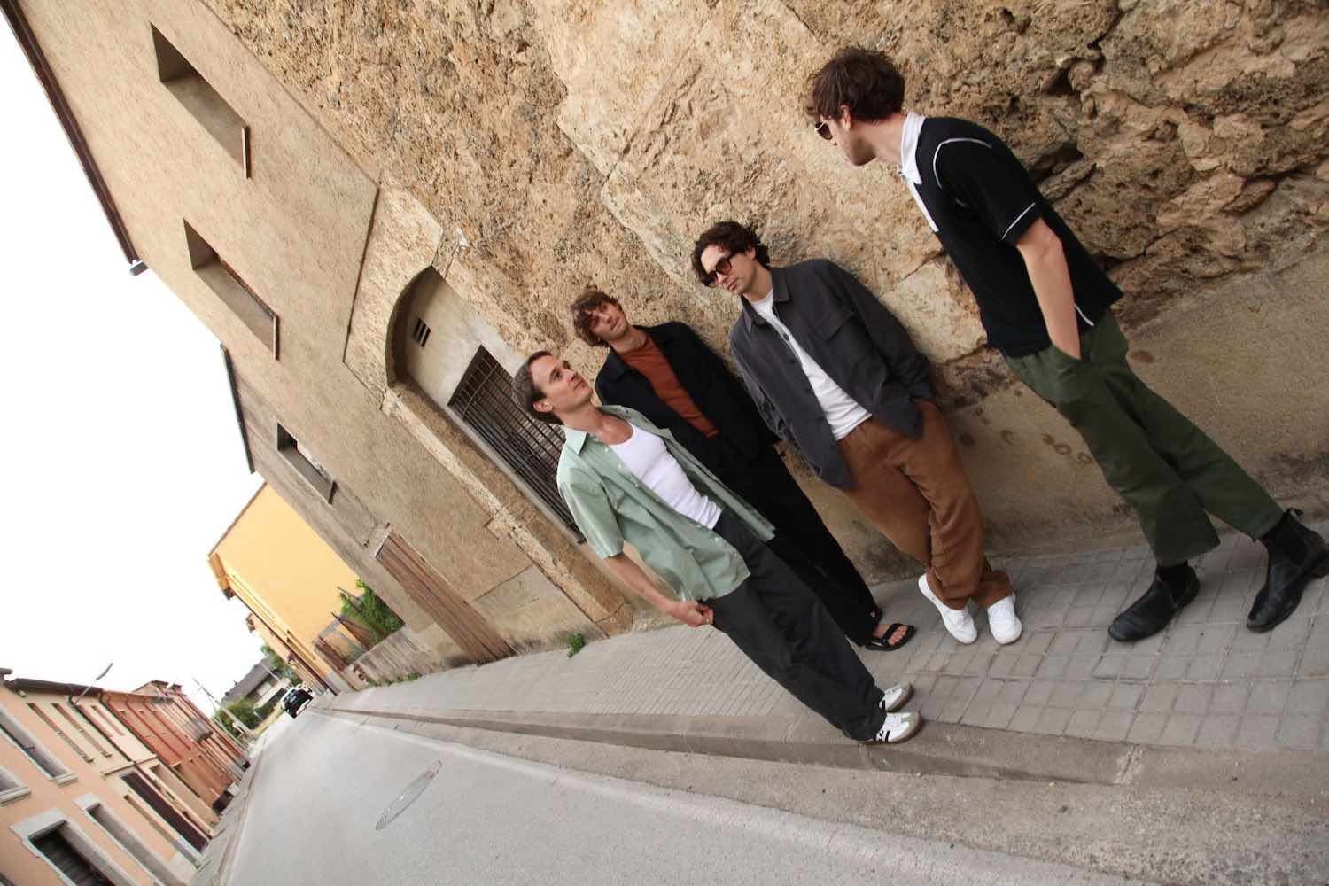 The four members on a stone ramp beside a rock face